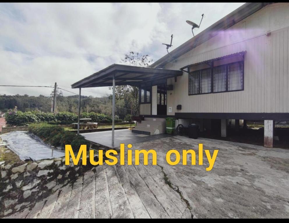 a house with amustlin only sign in front of it at Rizkie homestay in Tanah Rata