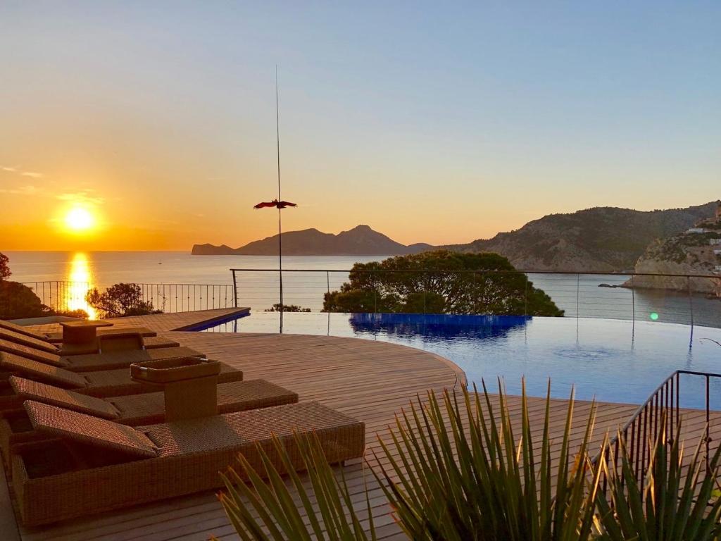 a pool with a view of the ocean at sunset at Modern Andratx Villa Ocean Views, 1031 in Andratx