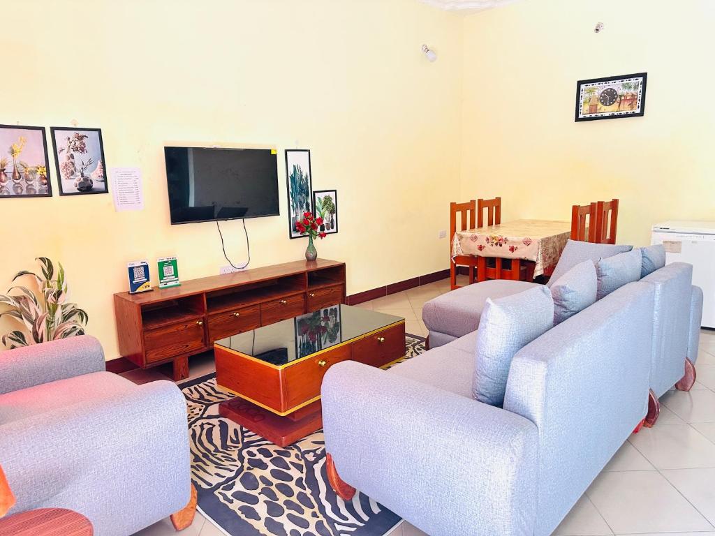 un soggiorno con divani e TV a schermo piatto di Pearl Lulu -3 Bedroom Apartments near Zanzibar Ferry and DownTown a Dar es Salaam