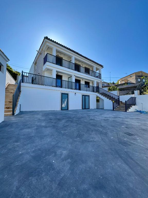 a large white house with a large parking lot at Cíes Suitel Prado in Nigrán