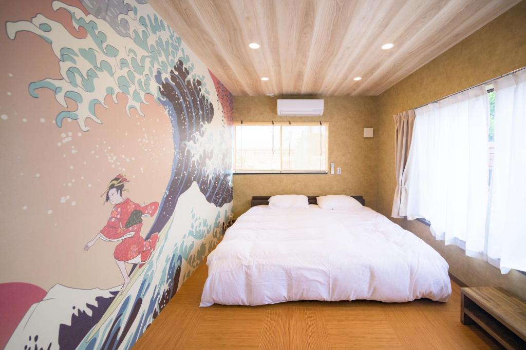 茅ヶ崎市にあるSeaBreeze Shirahama Seaside Retreat for Family and Work Stayの大きな絵画が壁に描かれたベッドルーム