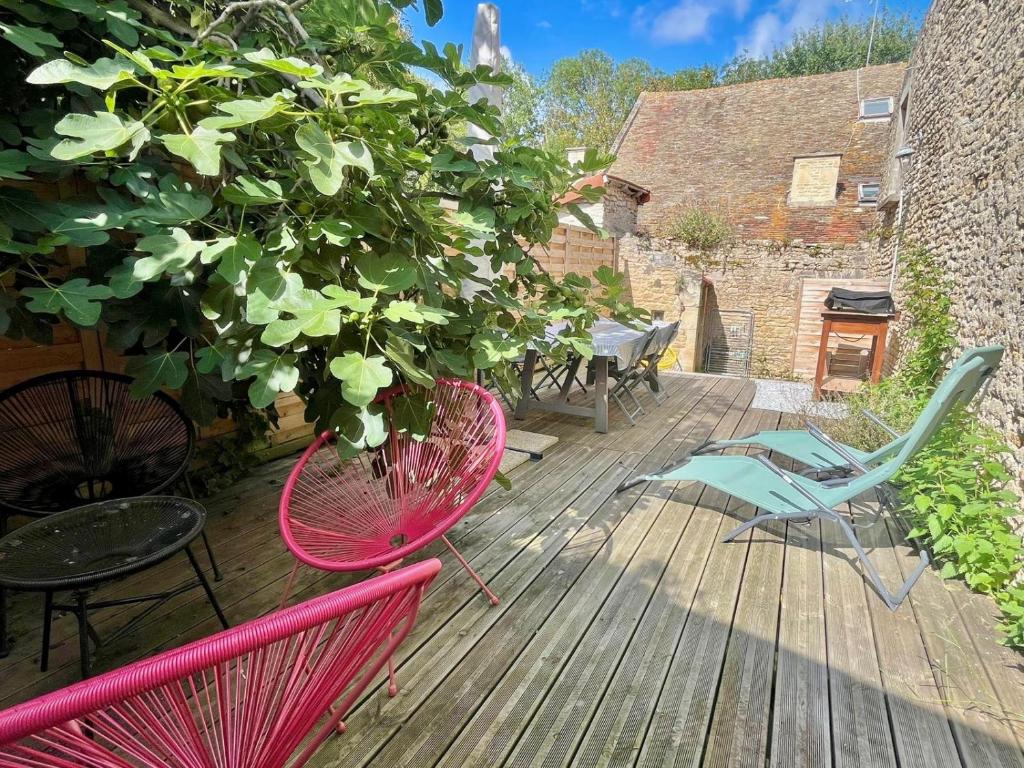 a deck with chairs and a potted plant on it at Petite vague - maison atypique avec terrasse in Saint-Aubin-sur-Mer
