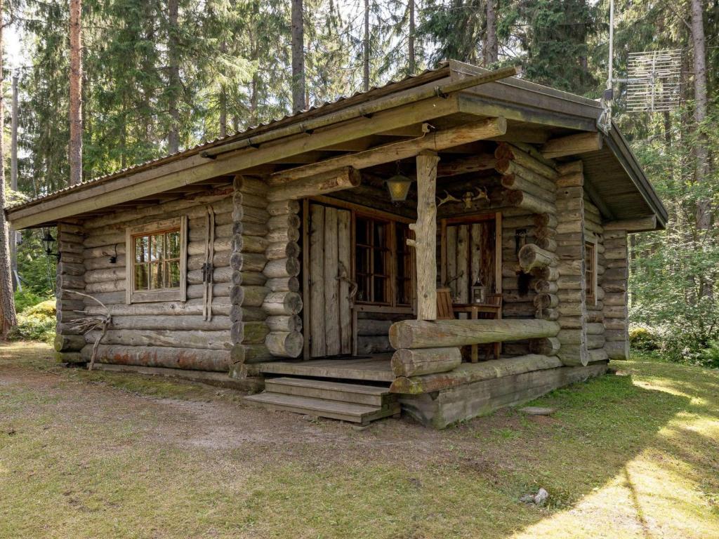 a log cabin in the middle of a forest at Holiday Home Rinnekämppä by Interhome in Pätiälä