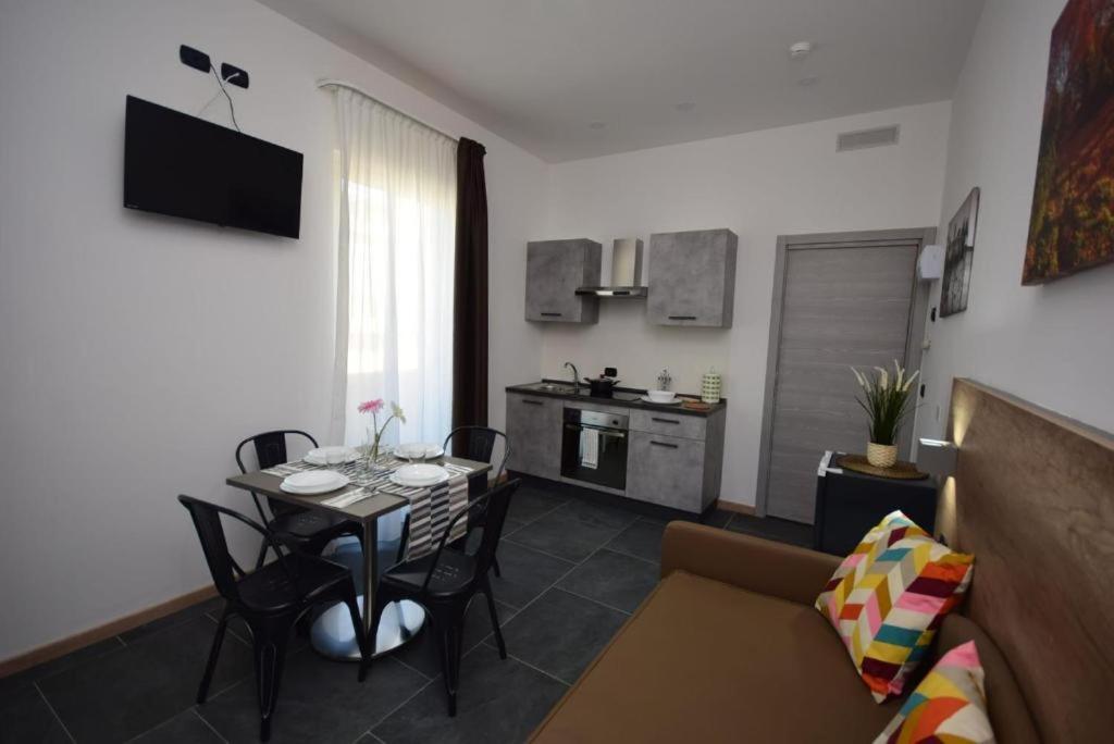 a living room with a table and a couch and a kitchen at New Comfort Apartment Igea Marina in Bellaria-Igea Marina