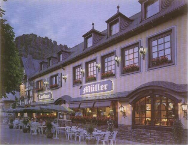 a large building with tables and chairs in front of it at Landhaus Müller in Alken