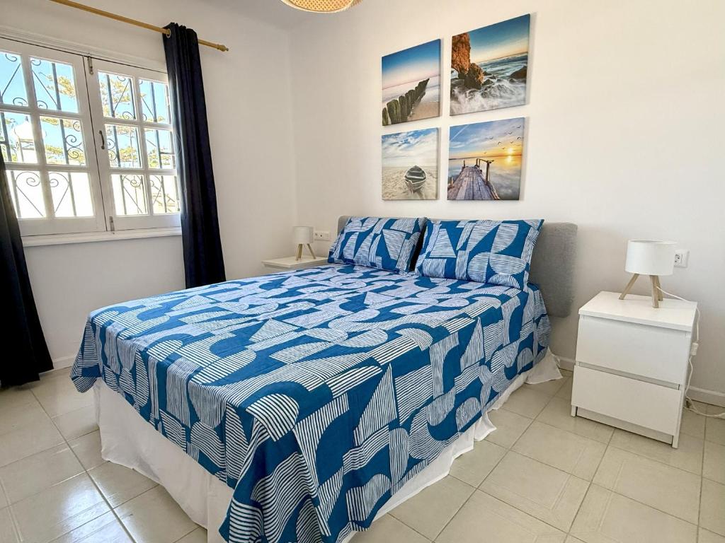 ein Schlafzimmer mit einem blau-weißen Bett und einem Fenster in der Unterkunft Horizonte Azul in Tías
