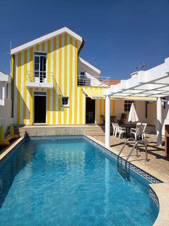 a yellow and white house with a swimming pool at Villa Nenúfares in Torreira