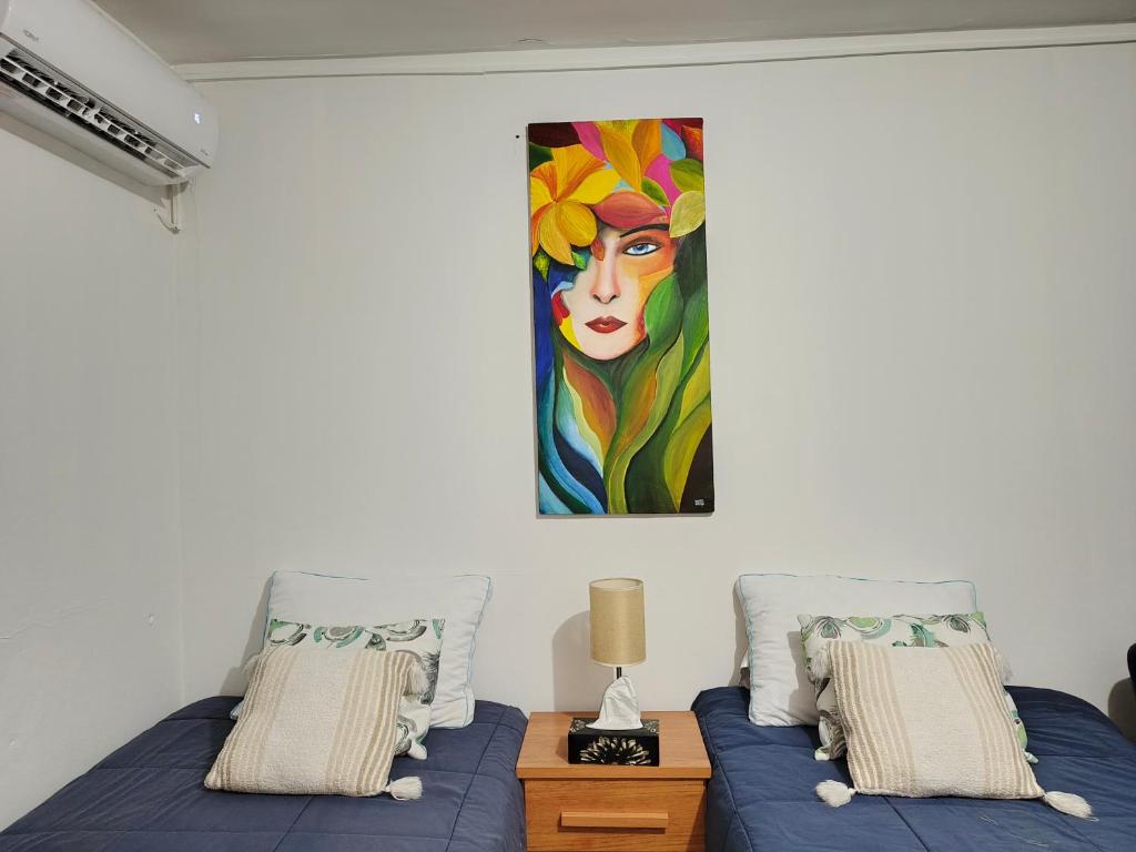 Dos camas en una habitación con un cuadro en la pared. en Second Home on The Beach, en La Libertad