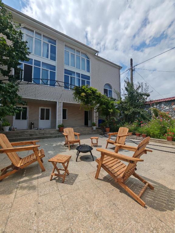 a group of wooden benches in front of a building at Villa Premium Qusar in Qusar