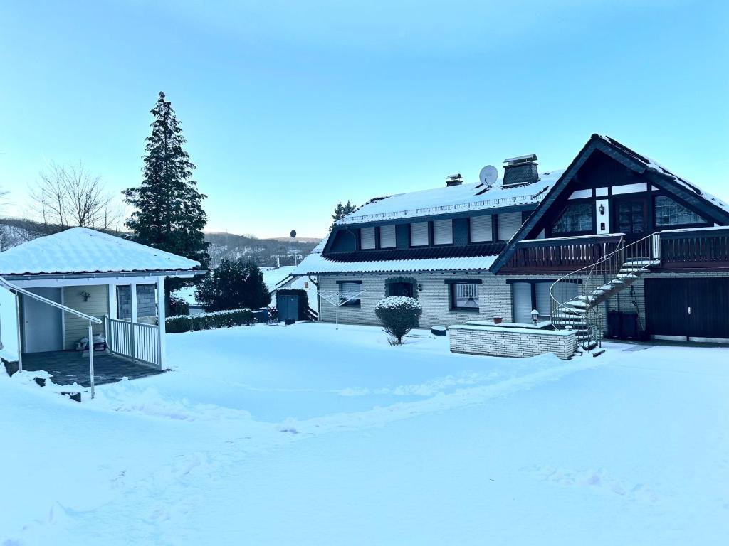 a house in the snow with a snow covered yard at Villa Eifelblick Loft-Apartment in Heimbach