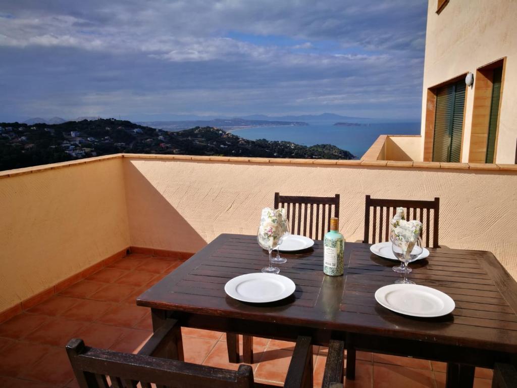 a wooden table with two plates on a balcony at 2 bedroom apartment close to the center of Begur. Terrace and panoramic sea views (Ref:H41) in Begur