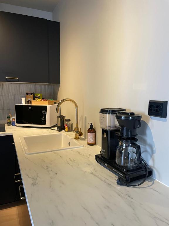 a kitchen counter with a coffee maker and a sink at Central apartment in Ålesund