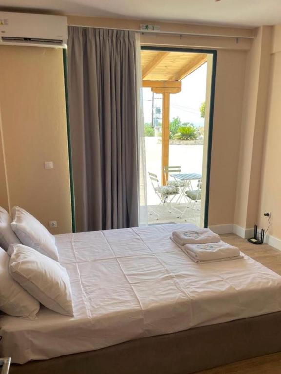 un grand lit dans une chambre avec une grande fenêtre dans l'établissement Seaview Oasis and Relaxation, à Paralia Dionisiou