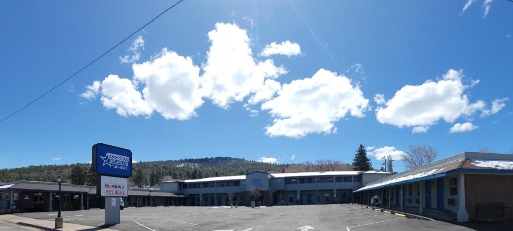 a parking lot in front of a building with clouds in the sky at Americas Best Value Inn-Williams/Grand Canyon in Williams