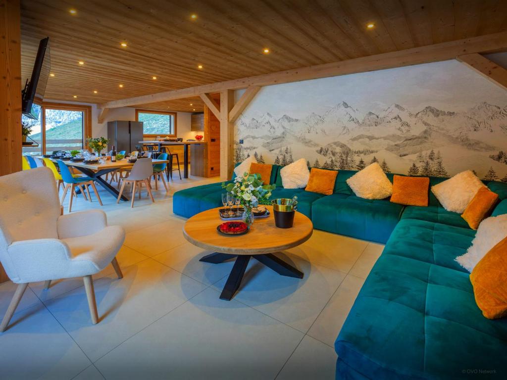 un soggiorno con un divano verde e un tavolo di Chalet Julero - OVO Network a Le Grand-Bornand