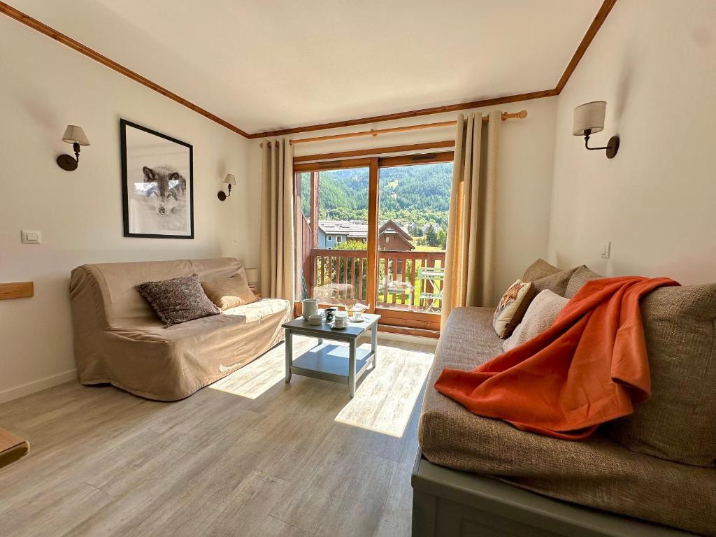 a living room with a couch and a table at DATCHA Joséphine Immobilier in La Salle Les Alpes