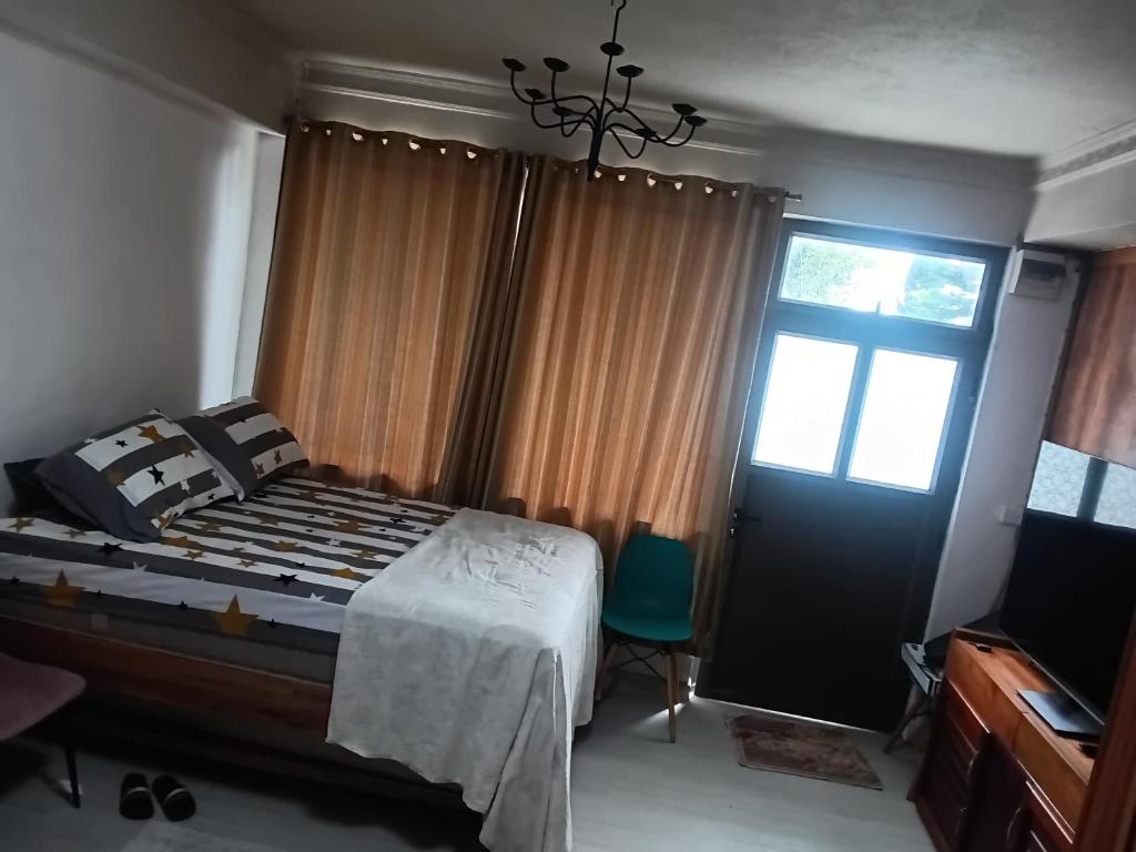 a bedroom with a bed and a window and a door at Cozy Studio Apartment in Quatre Bornes