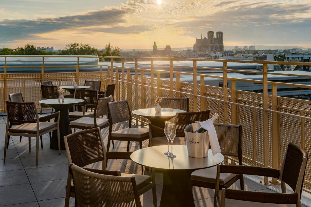 ランスにあるHoliday Inn Express & Suites Reims - Rives de Vesle by IHGのバルコニーにテーブルと椅子があるレストラン