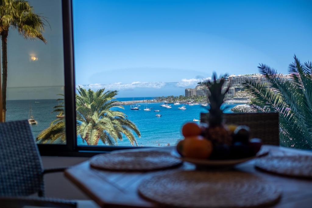 a table with a view of the ocean from a resort at Abora Mar - Beach Apartment in Patalavaca