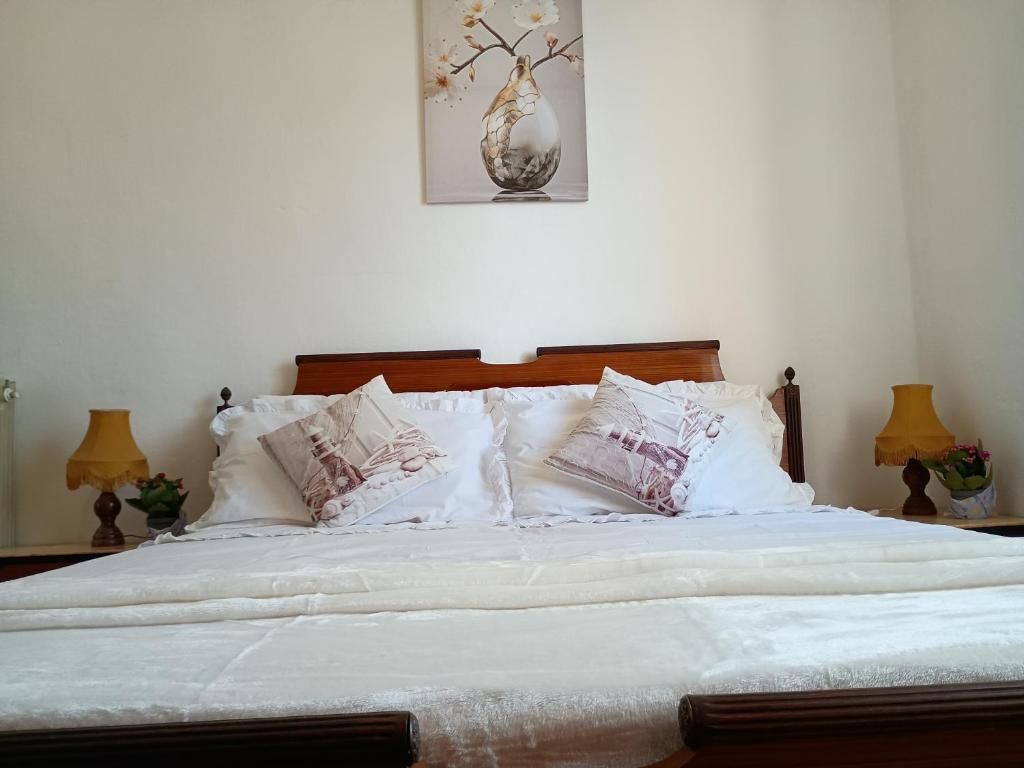 a bedroom with a bed with white sheets and pillows at Casa Vacanza Arzello in Melazzo
