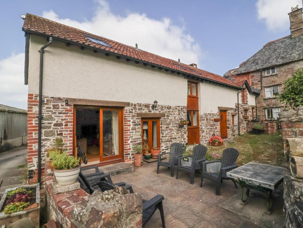 a patio of a house with chairs and a table at Lane End in South Molton