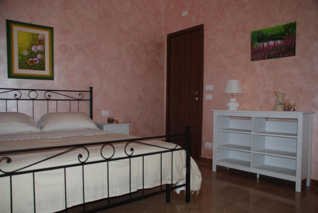 1 dormitorio con 1 cama, vestidor y puerta en Villino Amabile, en Fiumicino