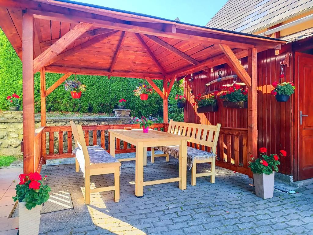 a wooden pergola with a wooden table and two chairs at Vilka Tkáč in Kvačany