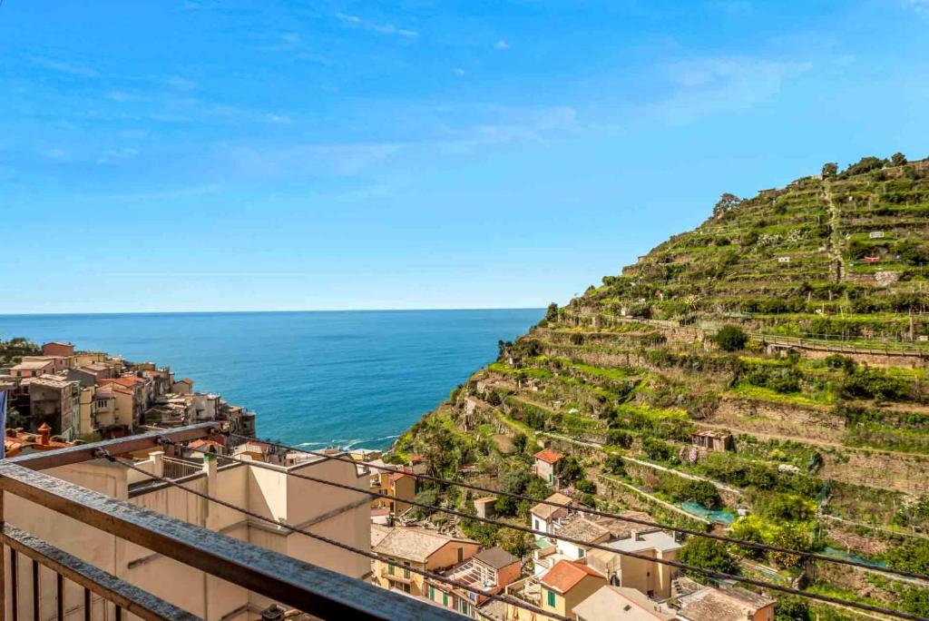 a town on a hill with the ocean in the background at MareMiele, TerreMarine in Manarola