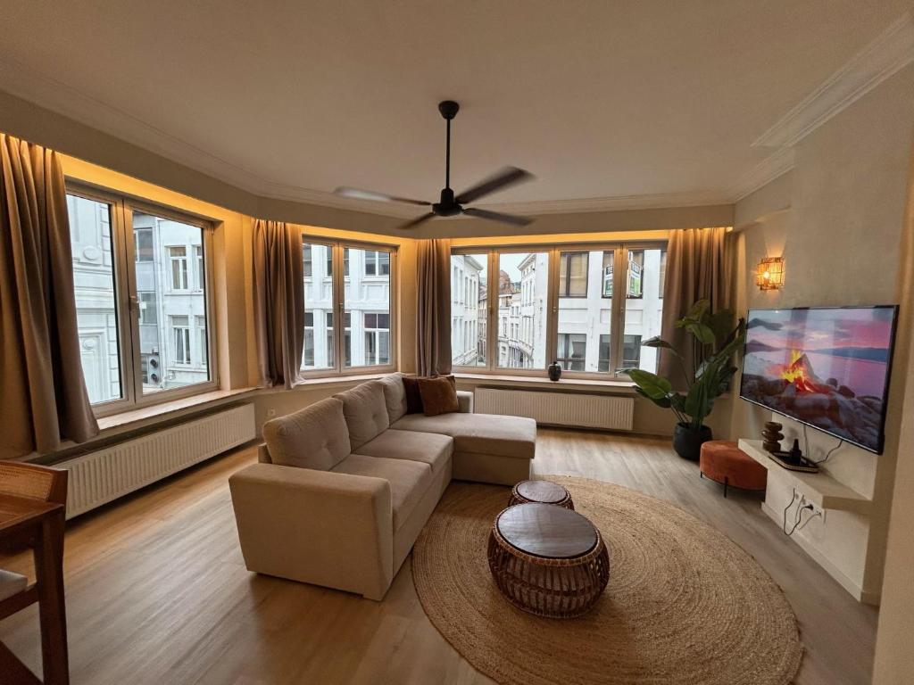 a living room with a couch and a tv at Japandi Lofts - 2 Bedrooms at old city of Antwerp in Antwerp