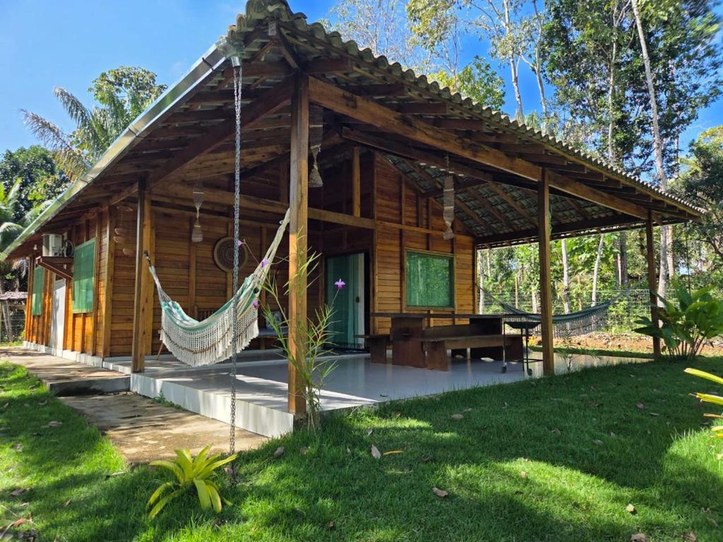a log cabin with a hammock in front of it at Cabana das Mandalas in Itacaré