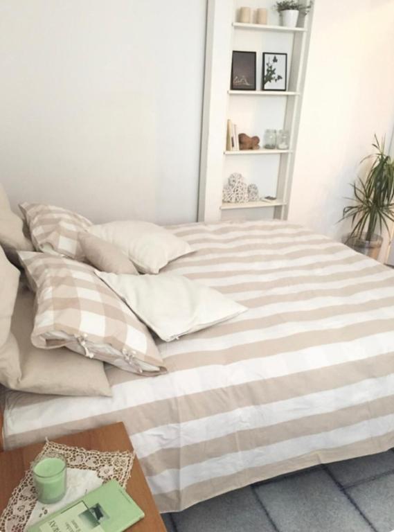 a bed with striped sheets and pillows in a room at Casa Laura a due passi dal mare in Rimini
