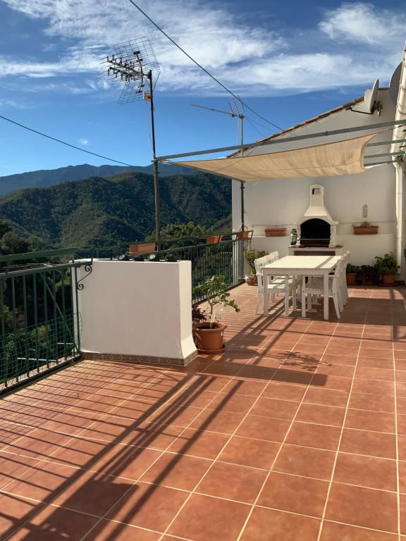 un patio con mesa y vistas a las montañas en Piso el Zorro, 40m2 Dachterrasse, en Istán
