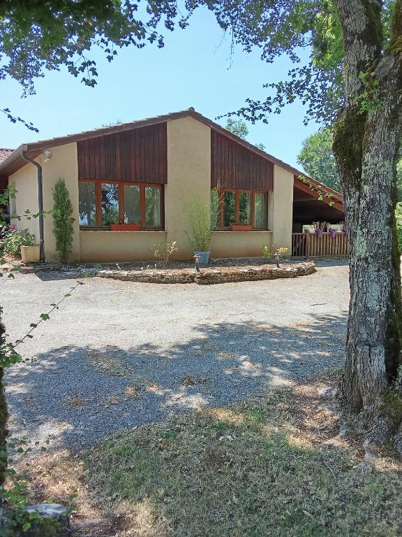 a house with a tree in front of it at La dame du bois in Gramat
