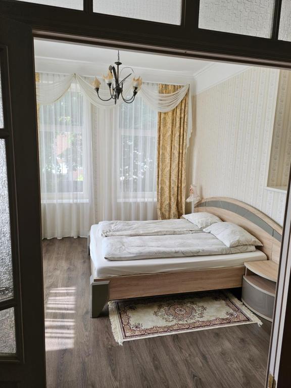 a bedroom with a large bed with a chandelier at Summer Lounch in Liepāja