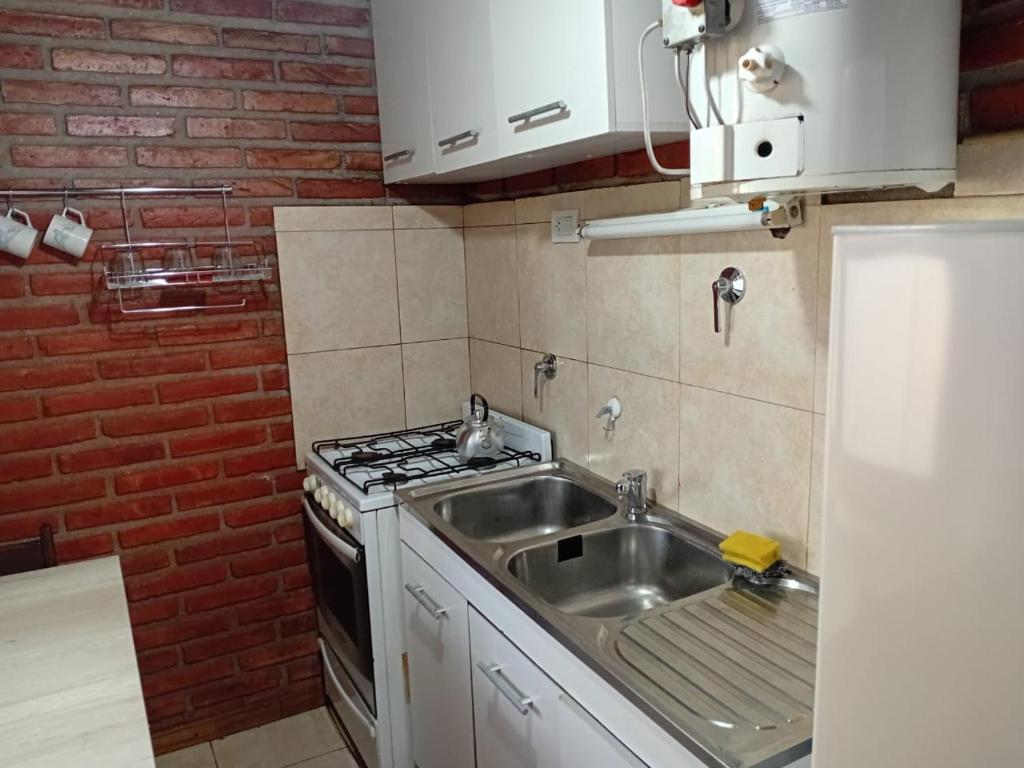 a kitchen with a sink and a stove at Cabañas Silvia Banegas in Santa Rosa de Calamuchita
