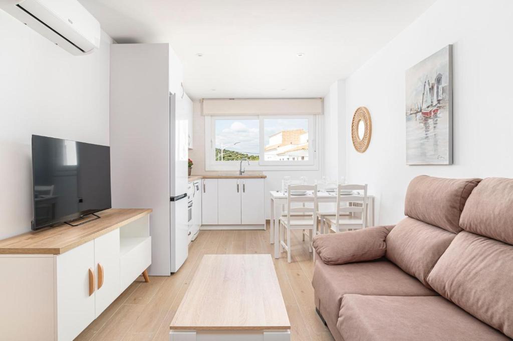 a living room with a couch and a kitchen at Apartamentos Almadraba in Zahara de los Atunes