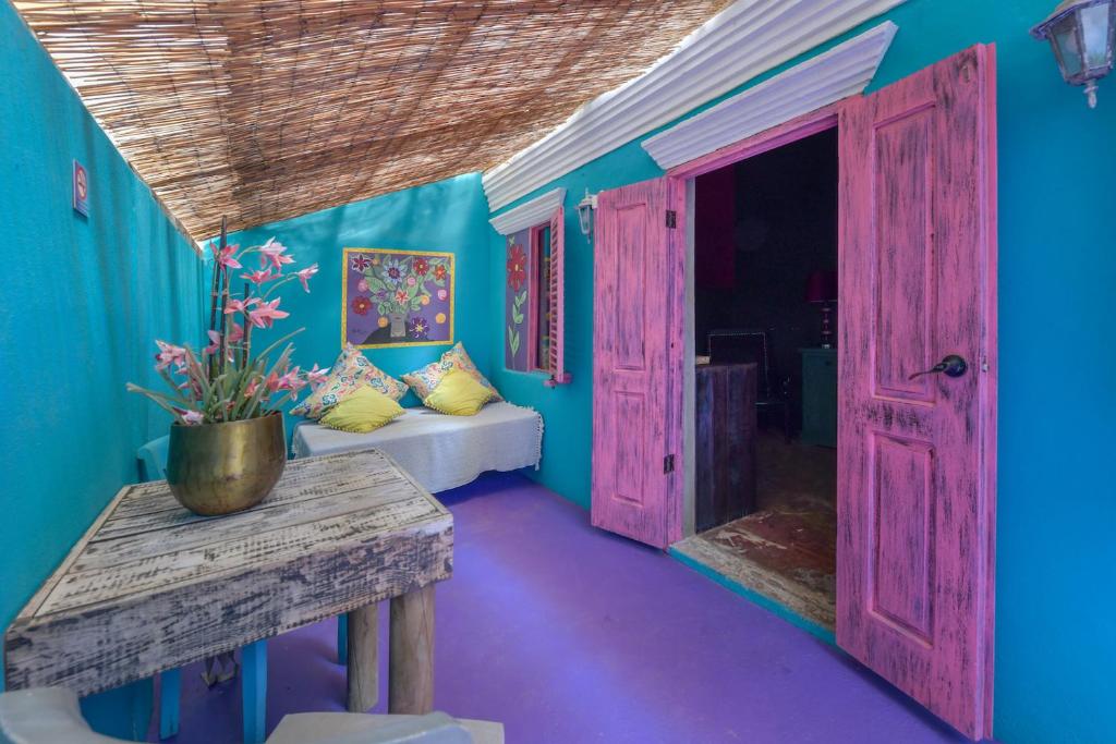 ein Zimmer mit blauen Wänden und einer offenen Tür in der Unterkunft Mammaloe in Oranjestad