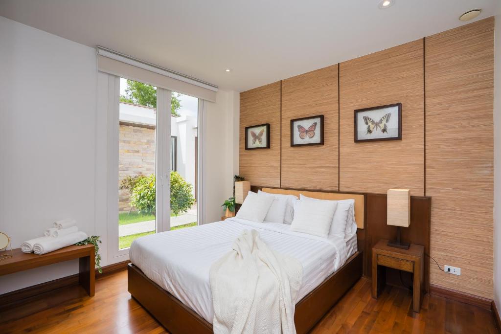a bedroom with a large bed and a window at Ocean View Japandi Sauna & Rooftop 3BR Pool Villa in Khao Tao