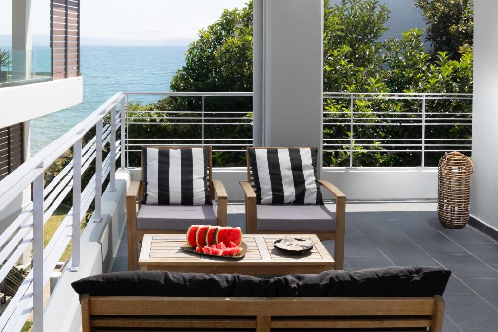 a patio with two chairs and a table on a balcony at Amare Luxury Living in Volos