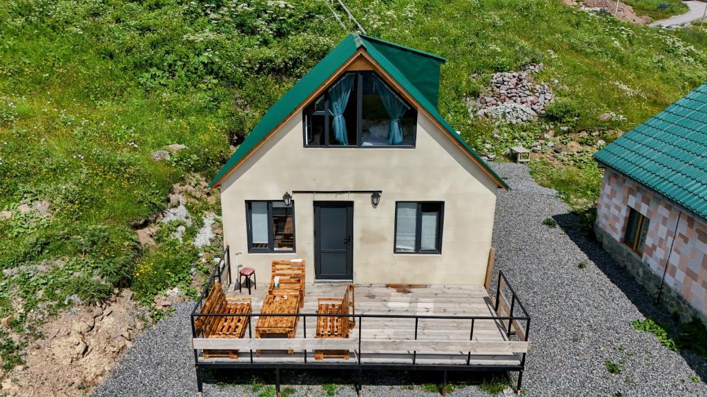 Cette chambre offre une vue sur une petite maison dotée d'une terrasse couverte. dans l'établissement Gudauri Private Cottage 2, à Goudaouri