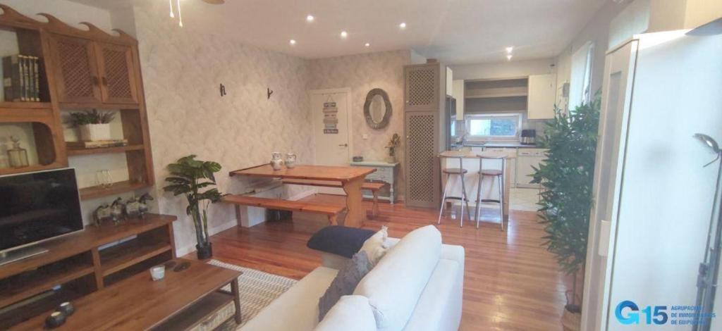 ein Wohnzimmer mit Couch und Tisch und eine Küche in der Unterkunft Apartamento El Olivar in San Sebastián