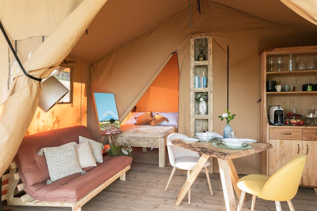 a tent with a table and a dining room at Etna Glamping in Milo