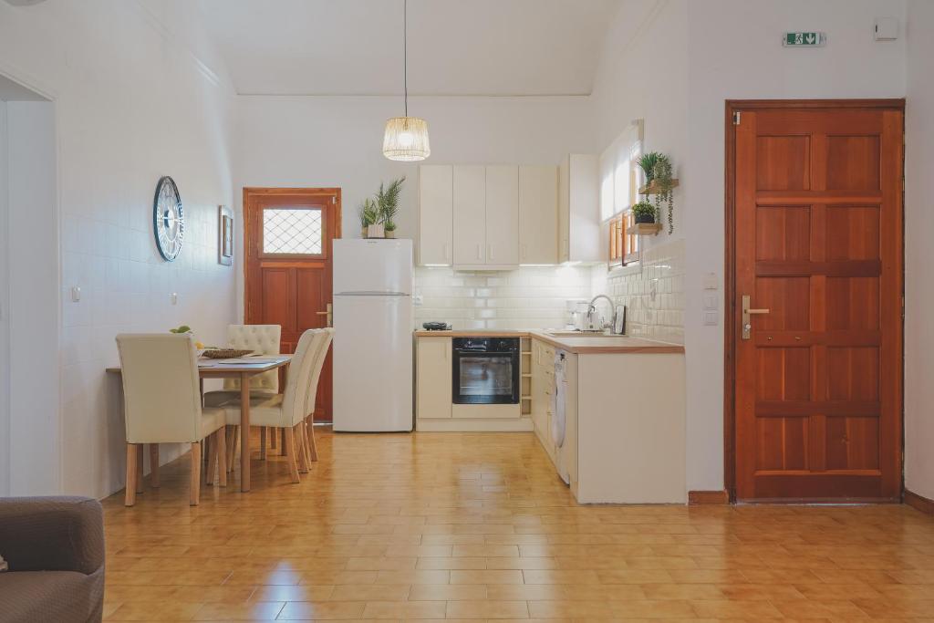a kitchen with white appliances and a table with chairs at Sea house of Candia in Kandia