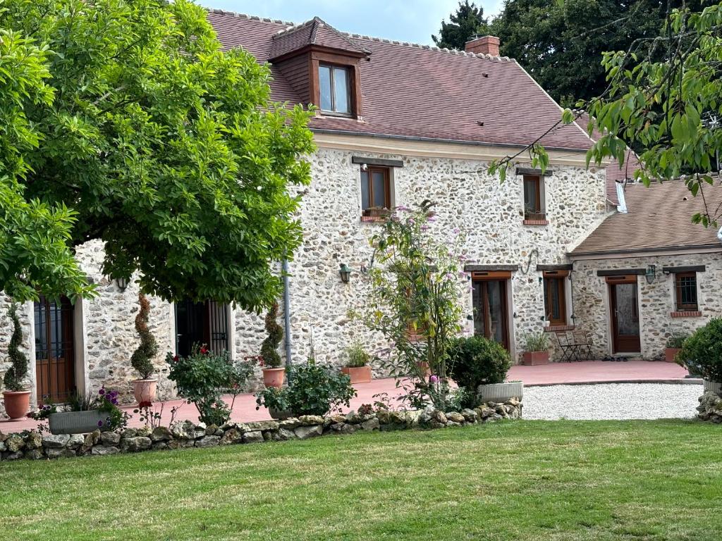 a large stone house with a yard at Le magnolia in Épieds