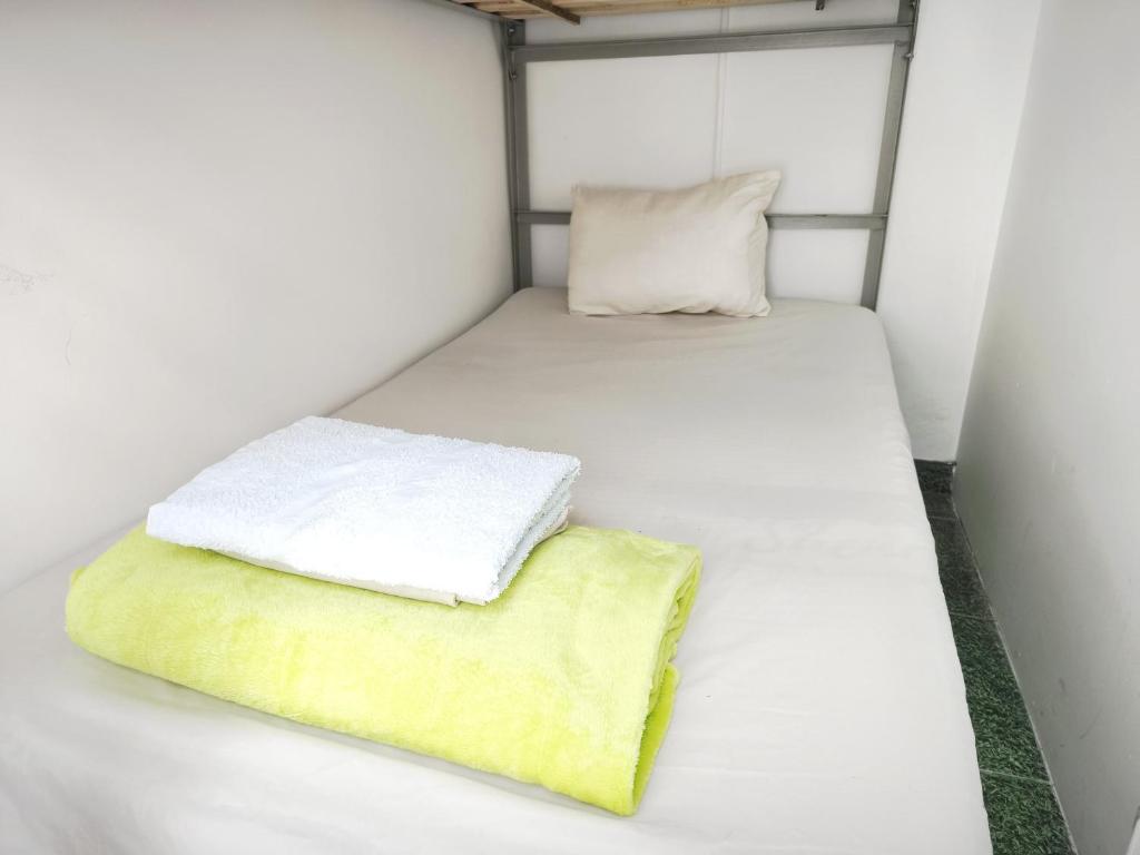 Habitación pequeña con 2 camas y almohada en Kuyay Yachi Hostel, en Bogotá