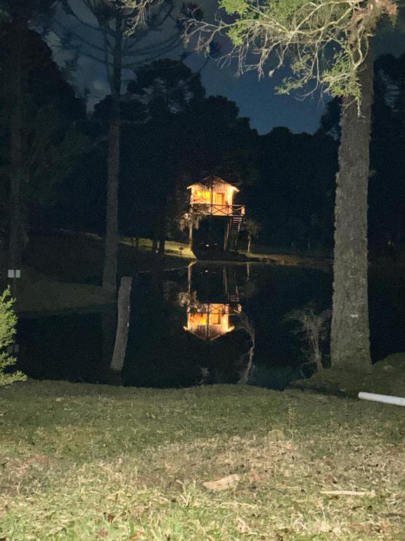 a house in the middle of a lake at night at Cabanas Imbuia in Cambara do Sul