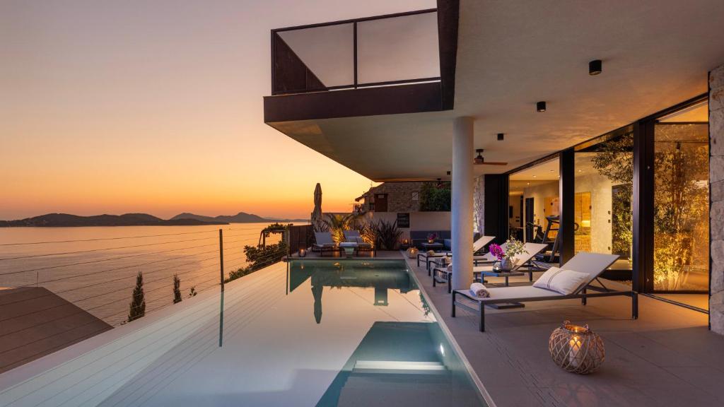 a villa with a swimming pool and a sunset at Villa Atreeum in Dubrovnik