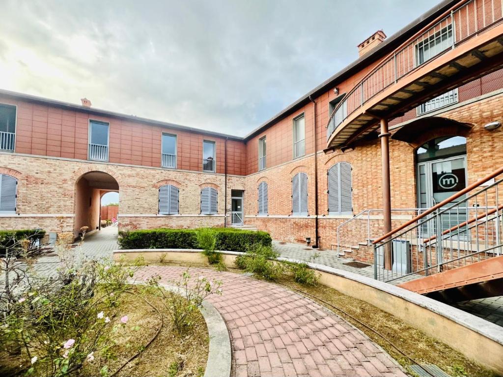 a brick building with a walkway in front of it at Deltasol in Montepulciano