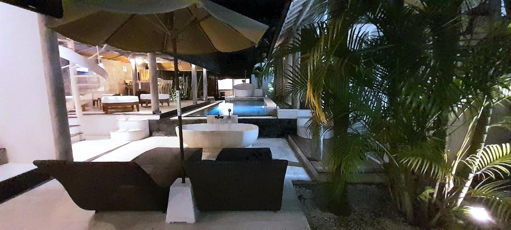 La salle de bains est pourvue d'un lavabo et d'un parasol. dans l'établissement PROMO! Private Vacation Rentals Villa, 2 Pools,4 Bedrooms,4 Bathrooms, Bali Seminyak, à Seminyak