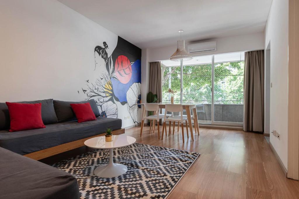 ein Wohnzimmer mit Sofa und Tisch in der Unterkunft Fliphaus Gregoria Perez 3500 'A' - 1 Bd Patio & BBQ Colegiales in Buenos Aires